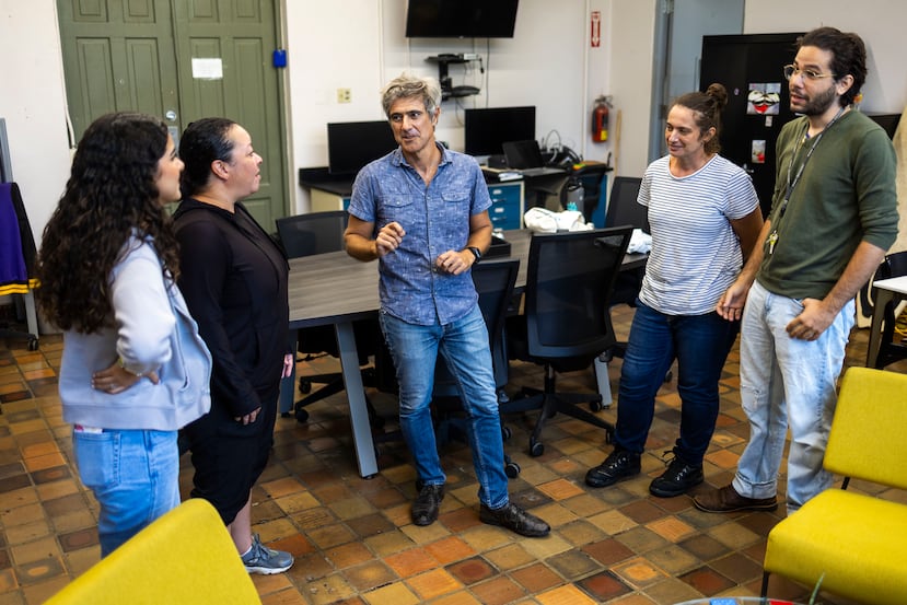 Dr Riccardo Papa (centre) talks with members of his team in the lab. To the right of the scientist is Elizabeth Evans, who also participated in the study.