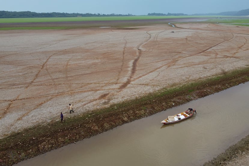Archive - Fishermen push a boat on Lake Aleixo in the middle of a drought, in Manaus, Brazil, on September 24, 2024. (AP Photo/Edmar Barros, Archive)